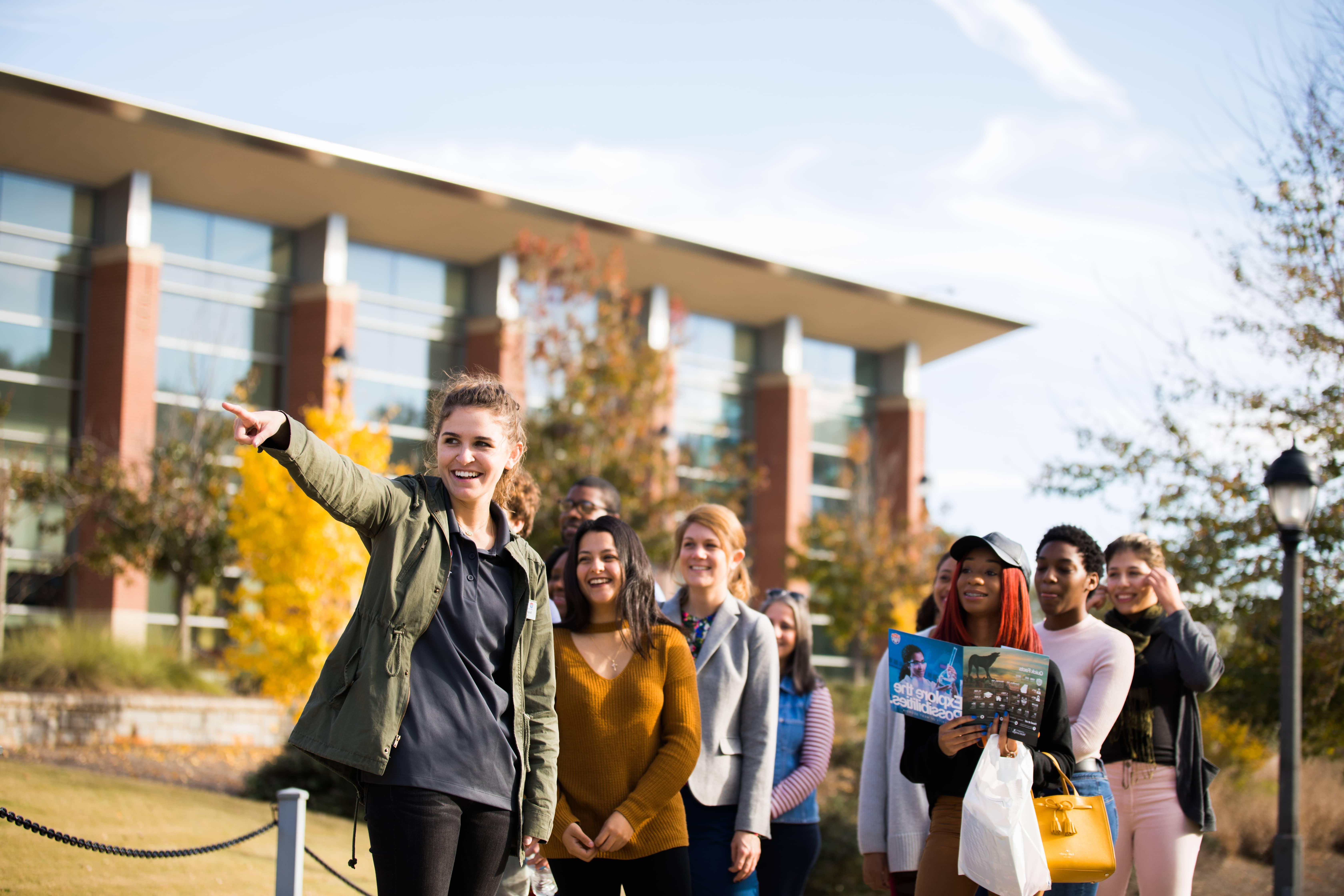 Students walking and smiling during a tour through campus.