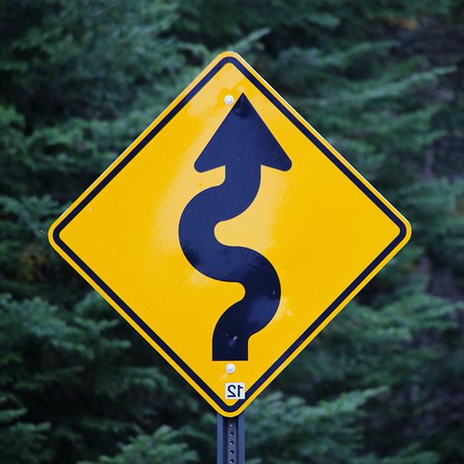 Photograph of a sign indicating a winding road ahead