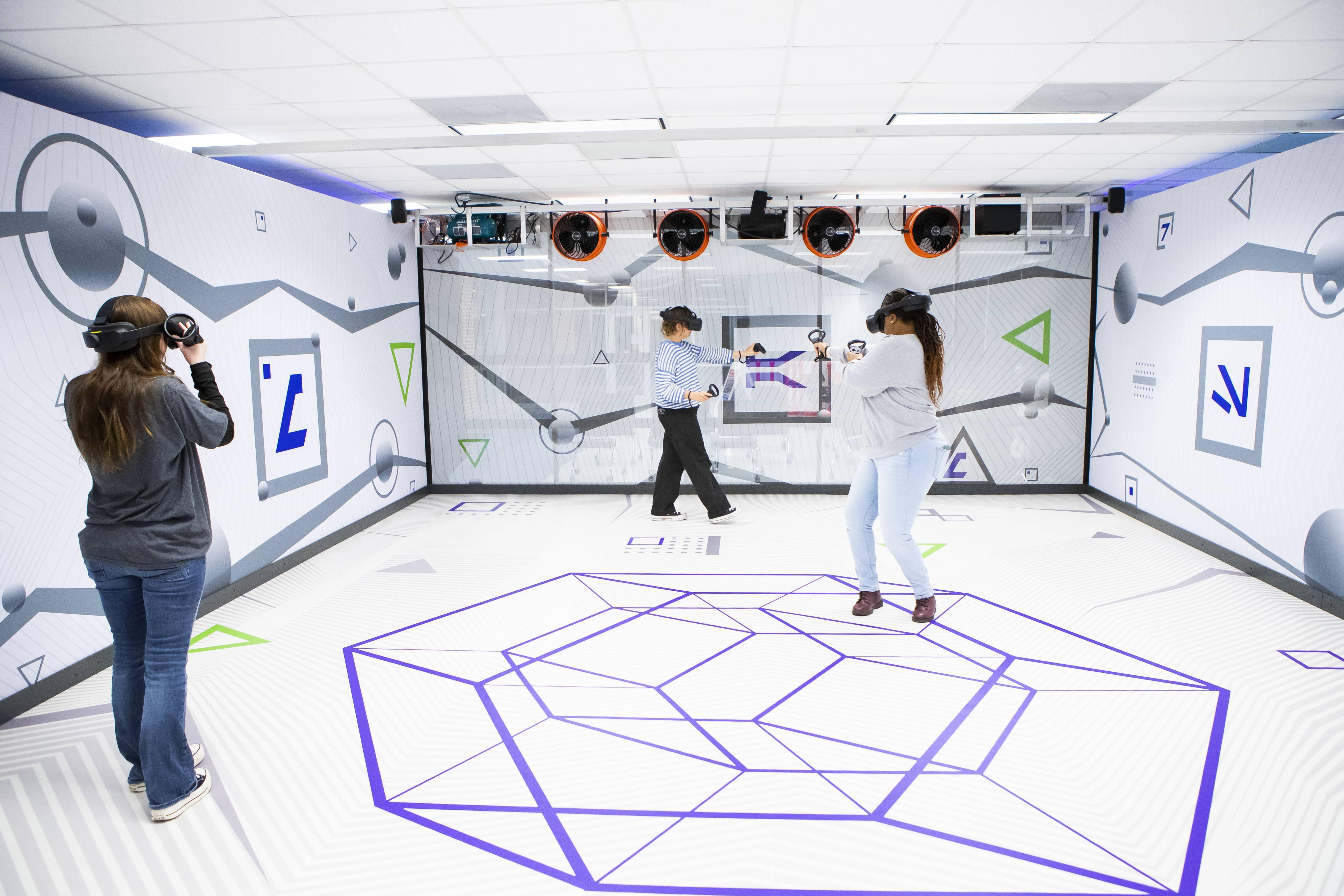 三个学生在虚拟现实教室里玩游戏.